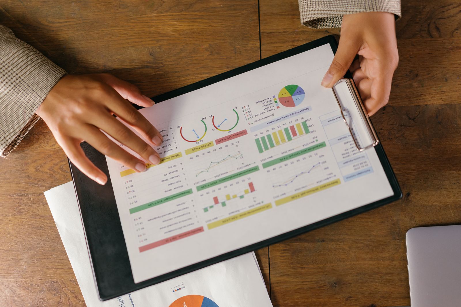 Mains feuilletant un rapport de données avec graphiques colorés pour préparer une décision